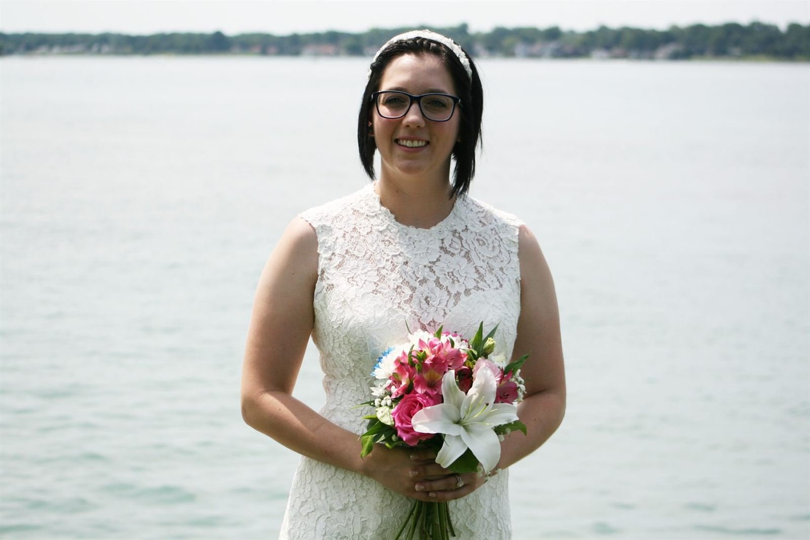 Bride by the water — bride holding a bouquet by a lake