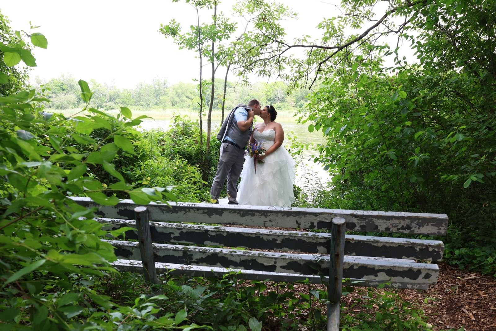 A quiet moment — couple kissing on a leafy path