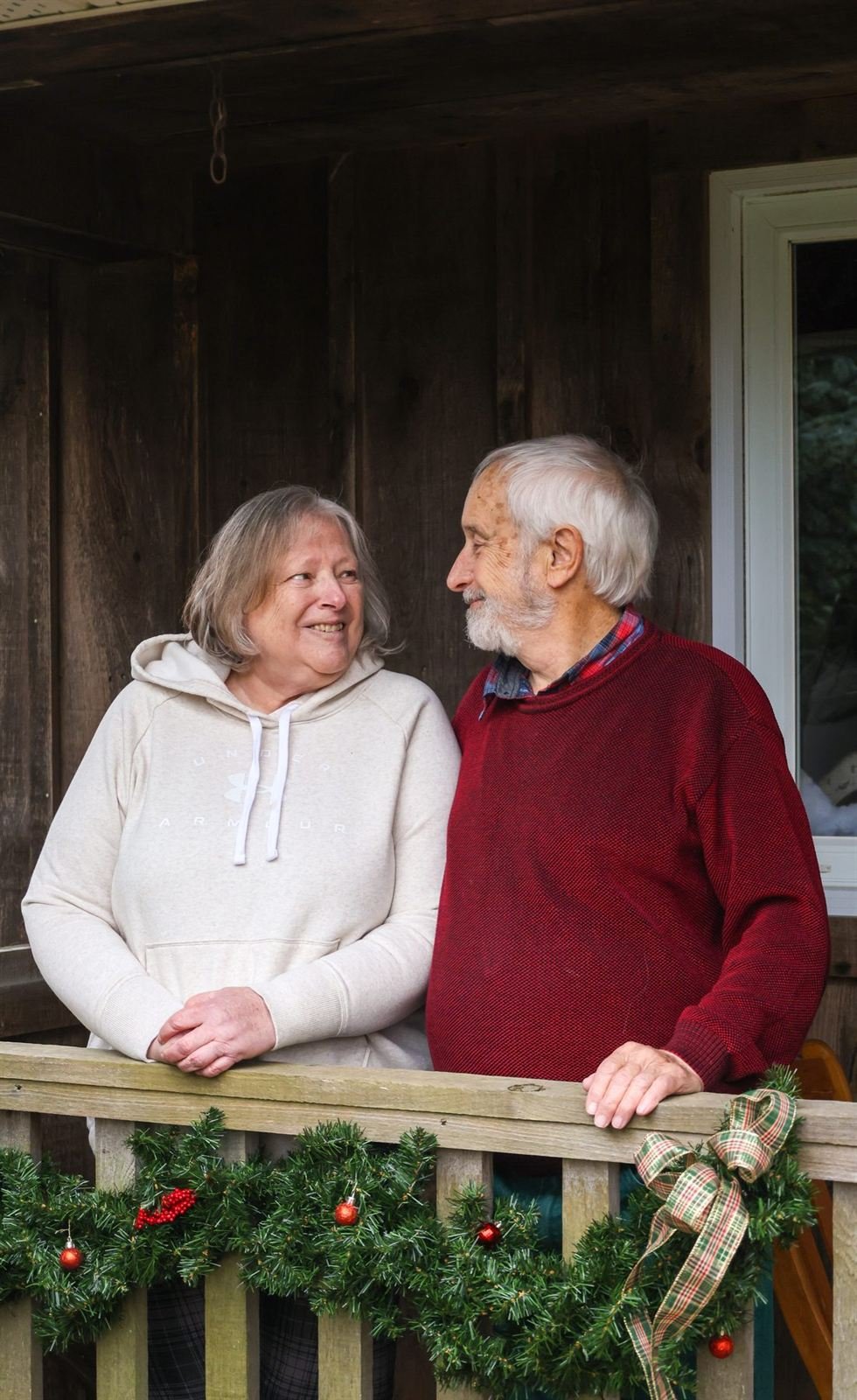 Porch season — couple on a porch with holiday garland