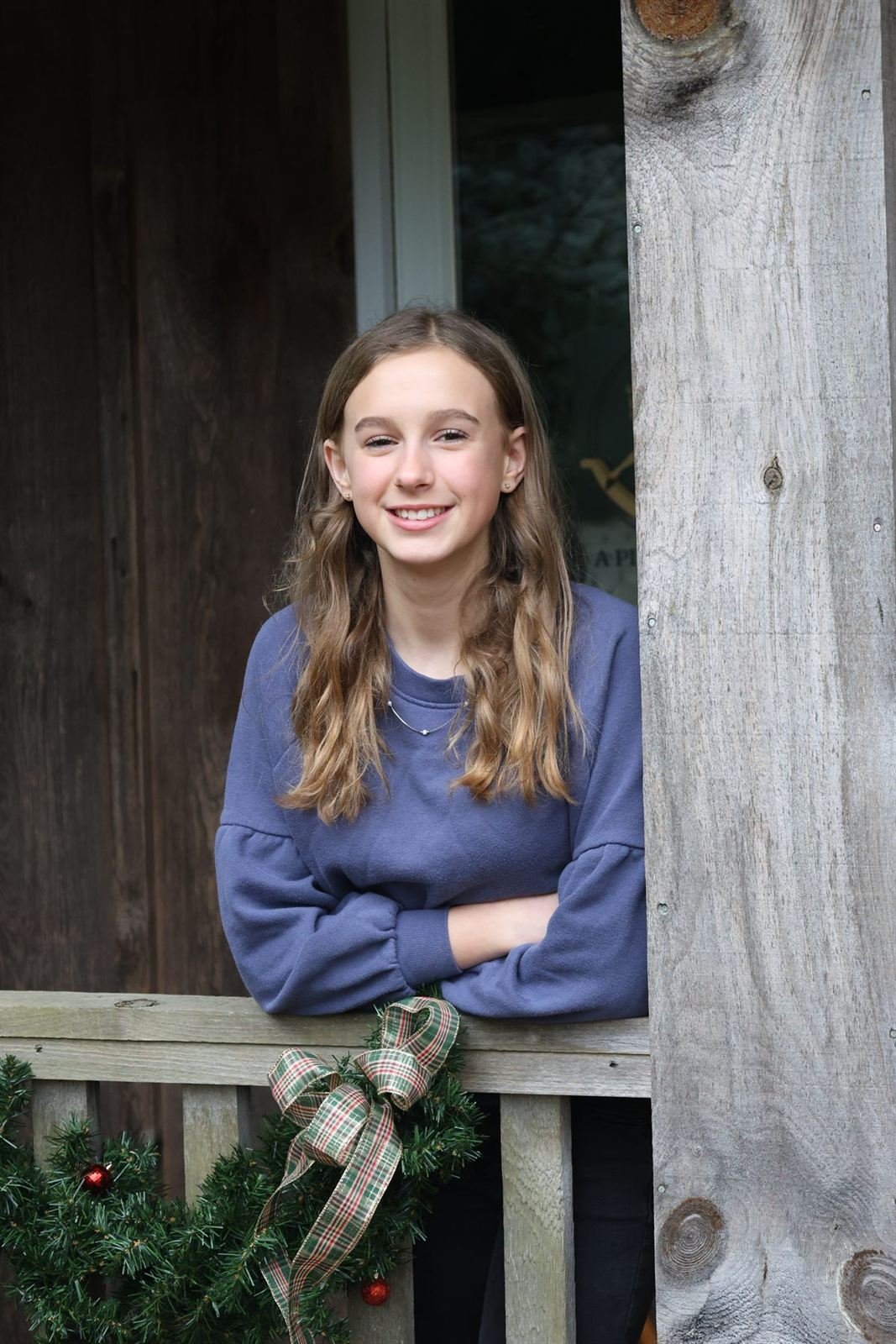 Holiday porch — girl smiling on a decorated porch